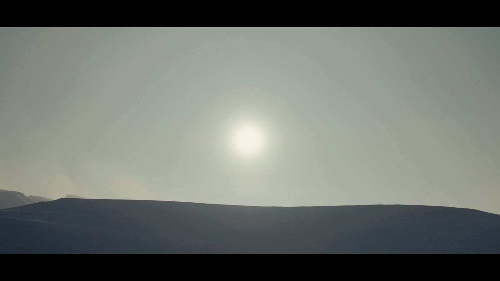 Le soleil derrière une montagne de neige